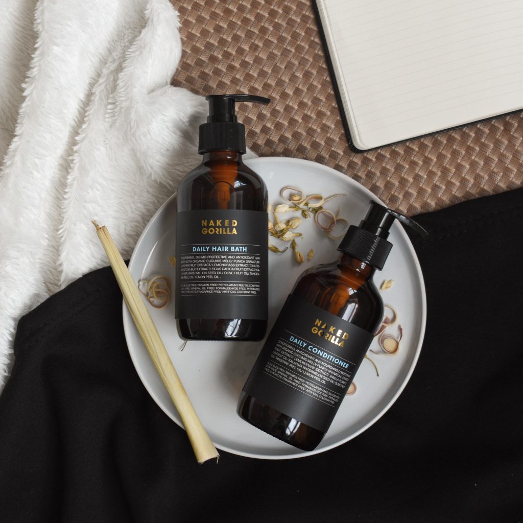 Naked Gorilla Daily Hair Bath shampoo and Daily Conditioner displayed on a white plate.