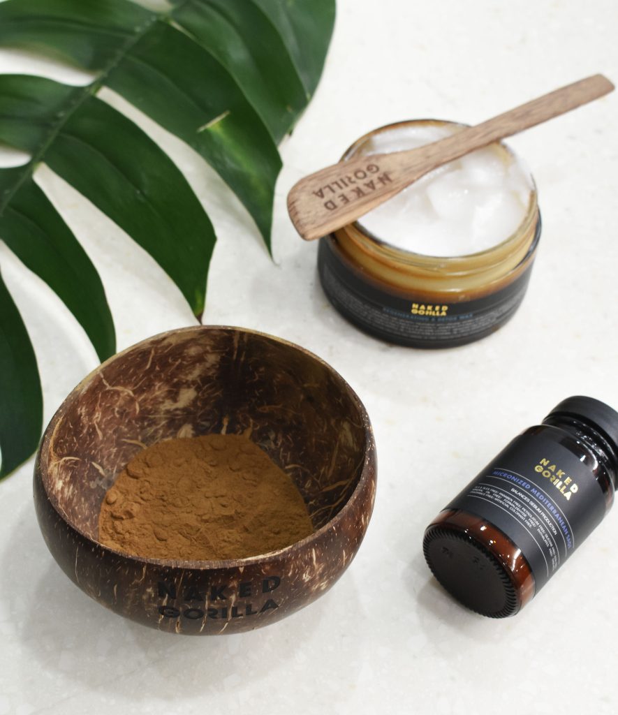 Naked Gorilla professional scalp treatment products displayed with a natural wooden bowl and spatula.